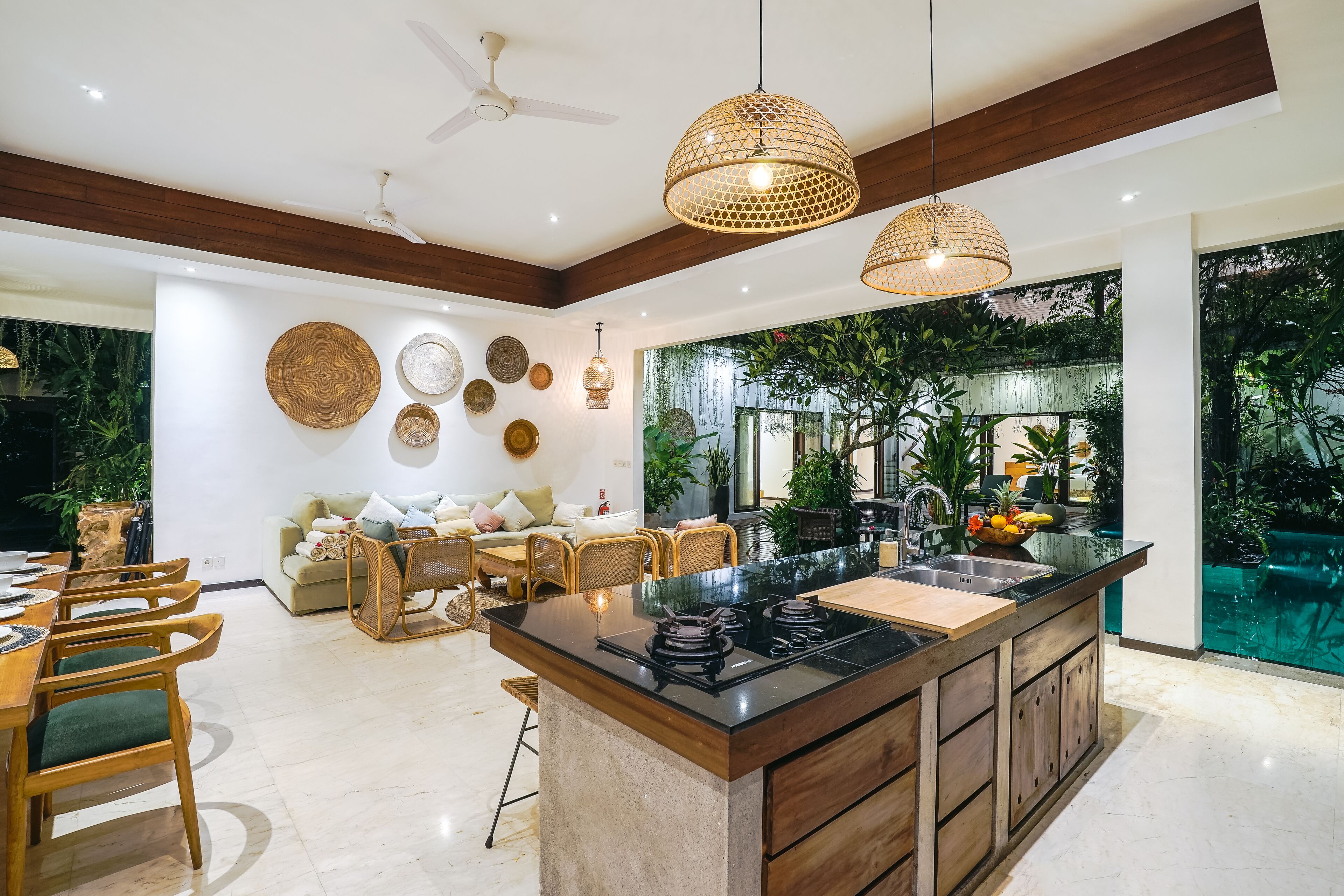 A modern kitchen with a central island, wooden chairs, and a dining area.