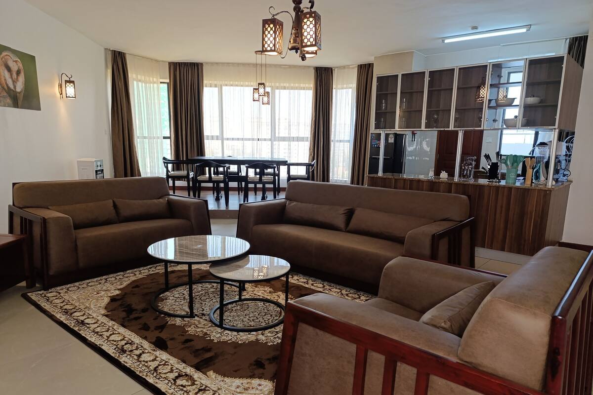 Un salon comprenant deux canapés, une table basse et un coin repas avec une table et des chaises.