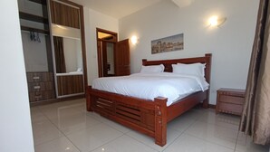 Un dormitorio con cama de madera, armario y baño con espejo.