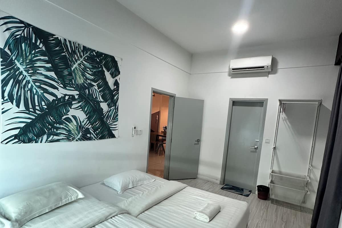 Habitació d'hotel moderna amb un llit gran, un armari, un mirall i aire condicionat fixat al sostre.