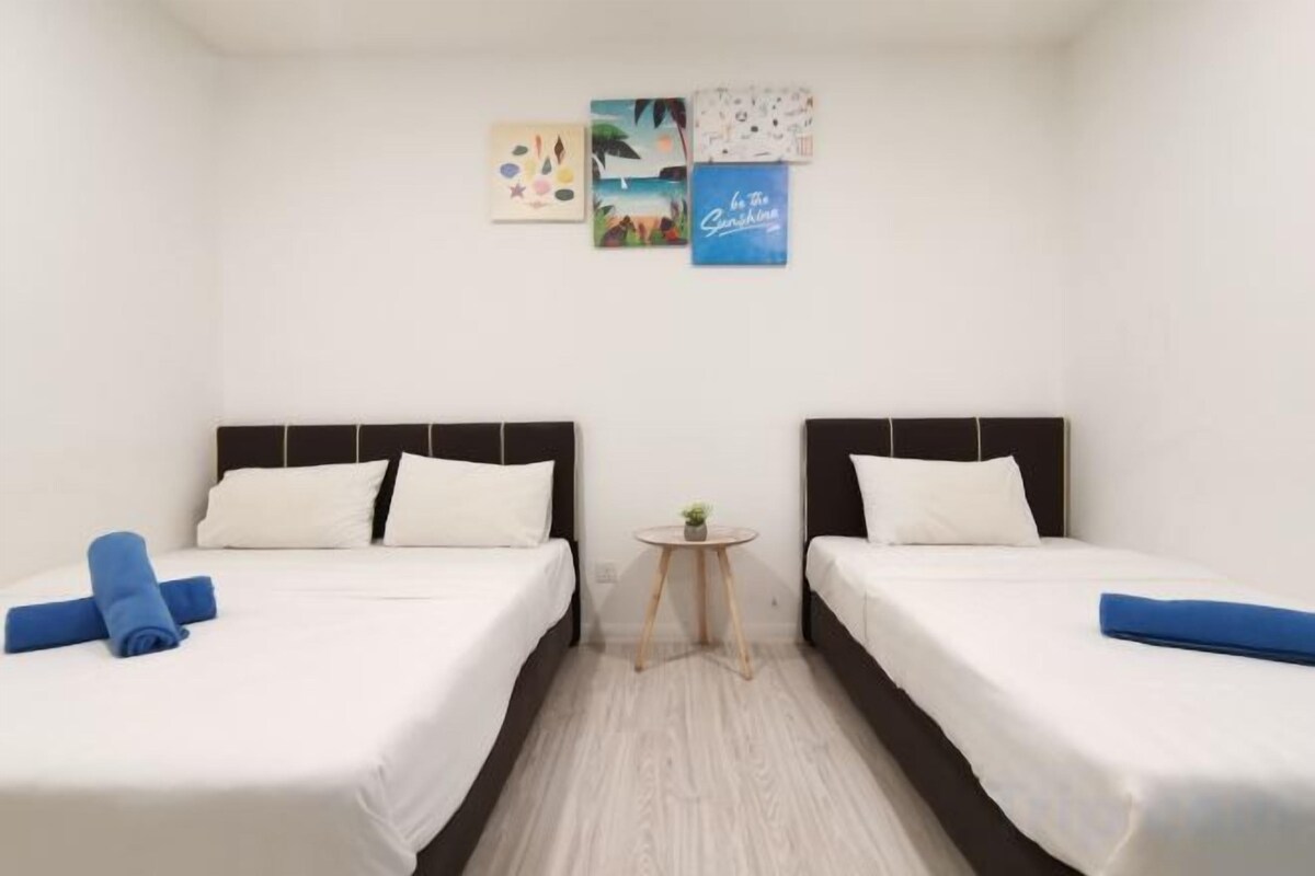 Une chambre d’hôtel avec deux lits, une petite table ronde et des œuvres d’art murales.