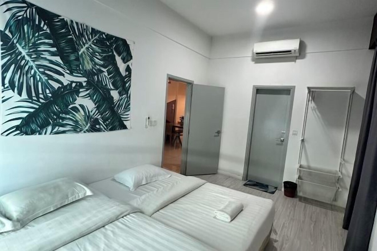 Une chambre d’hôtel moderne dotée d’un grand lit, d’un climatiseur fixé au mur et d’un placard à portes coulissantes.
