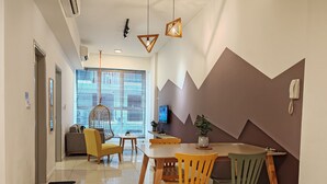 Un comedor moderno con una mesa alta, sillas y una lámpara colgante.