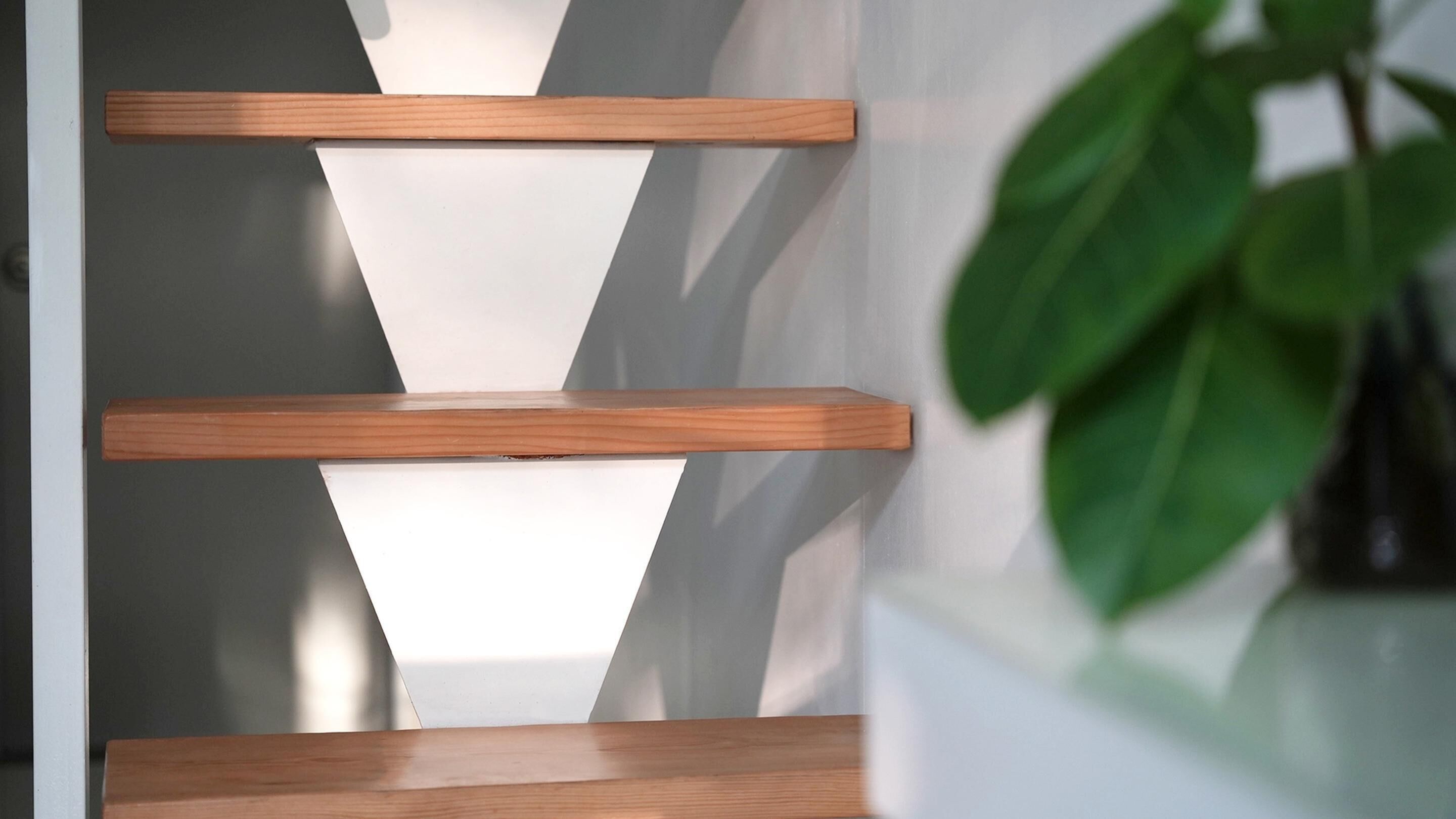 A modern interior with wooden shelves against a white wall.