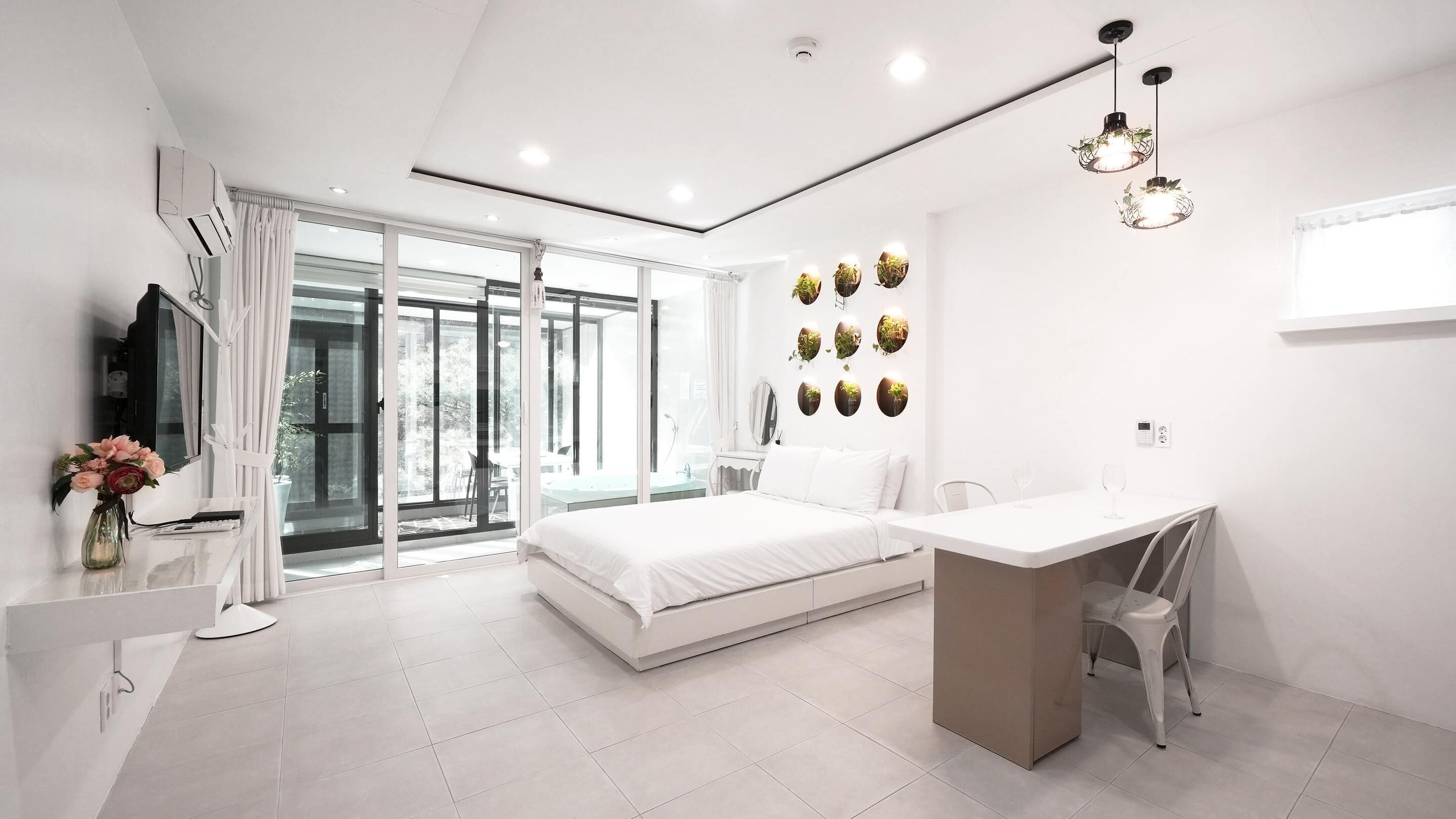 Een moderne slaapkamer met een bed, een bureau en een badkamer.