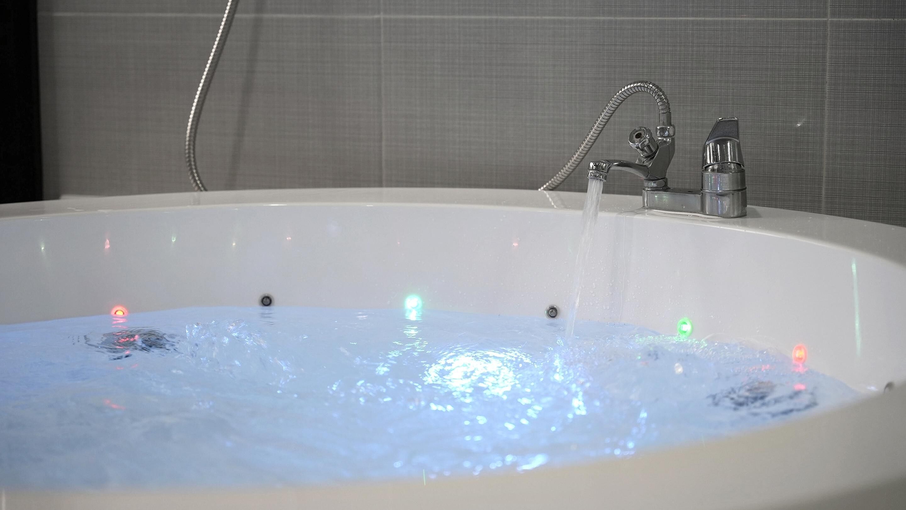Een badkuip met stromend water en LED-verlichting.