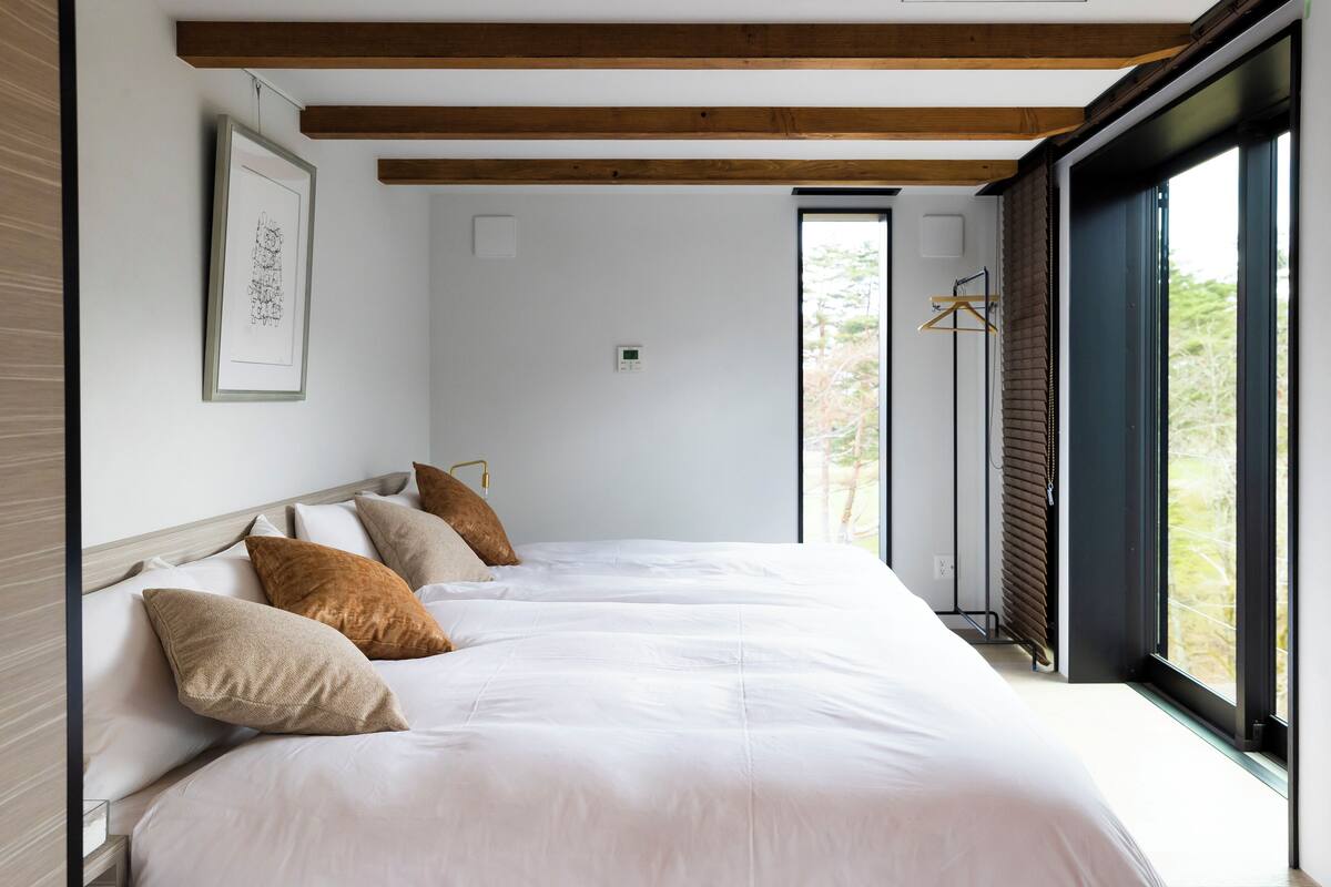 A bedroom with a large bed, a window, and a radiator.