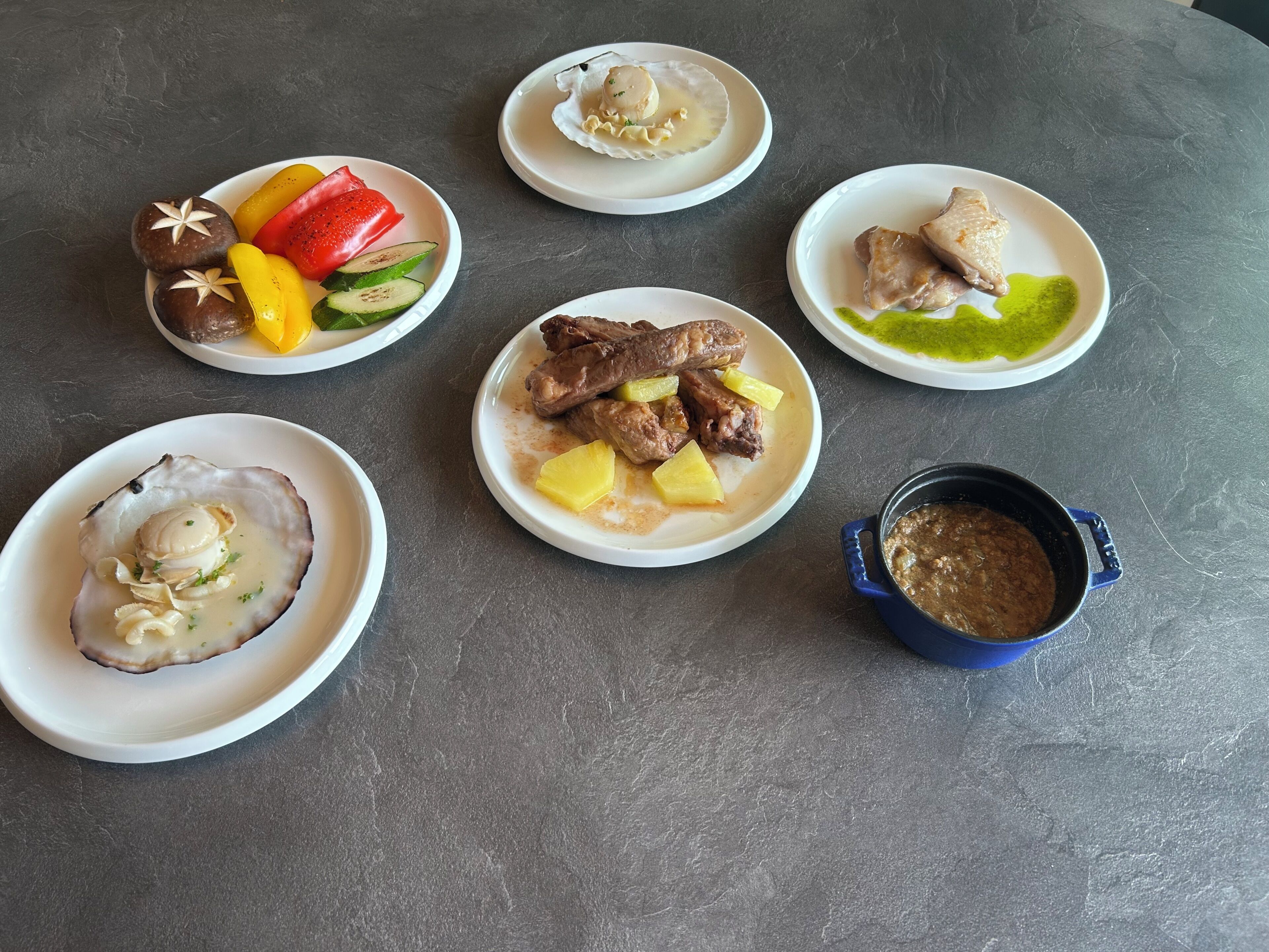 A table with various dishes including seafood, meat, and vegetables.