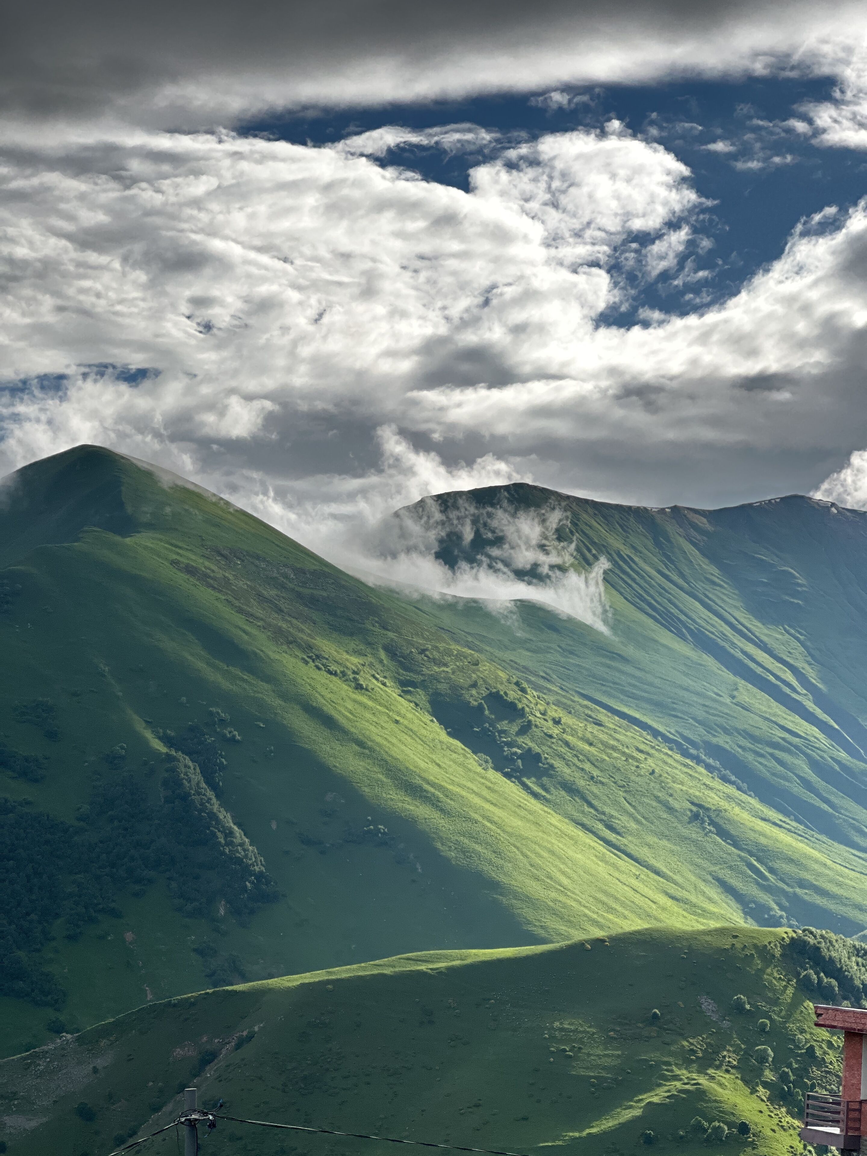 A mountain landscape with a prominent peak and a structure at the base, possibly a viewing platform or small building.