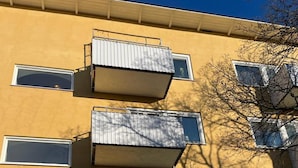 A yellow building with multiple balconies and windows. - 2 Room Apartment in Hammarby by Stockholm City (Johanneshov)