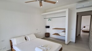 A modern bedroom with a large bed, a ceiling fan, and a minimalist design. - Sunset Villa with Infinity Pool (Las Terrenas)