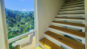 A staircase with wooden steps and white risers, leading to a balcony with a view of a lush green landscape. - Sunset Villa with Infinity Pool (Las Terrenas)