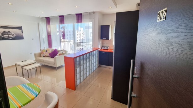 A modern apartment with a living area, kitchenette, and a balcony. - City Vibrance Apartment (Larnaca)