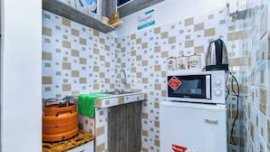 A compact kitchen with a microwave, a kettle, and a gas stove. - Lux Suites Nairobi House Naivasha (Naivasha)
