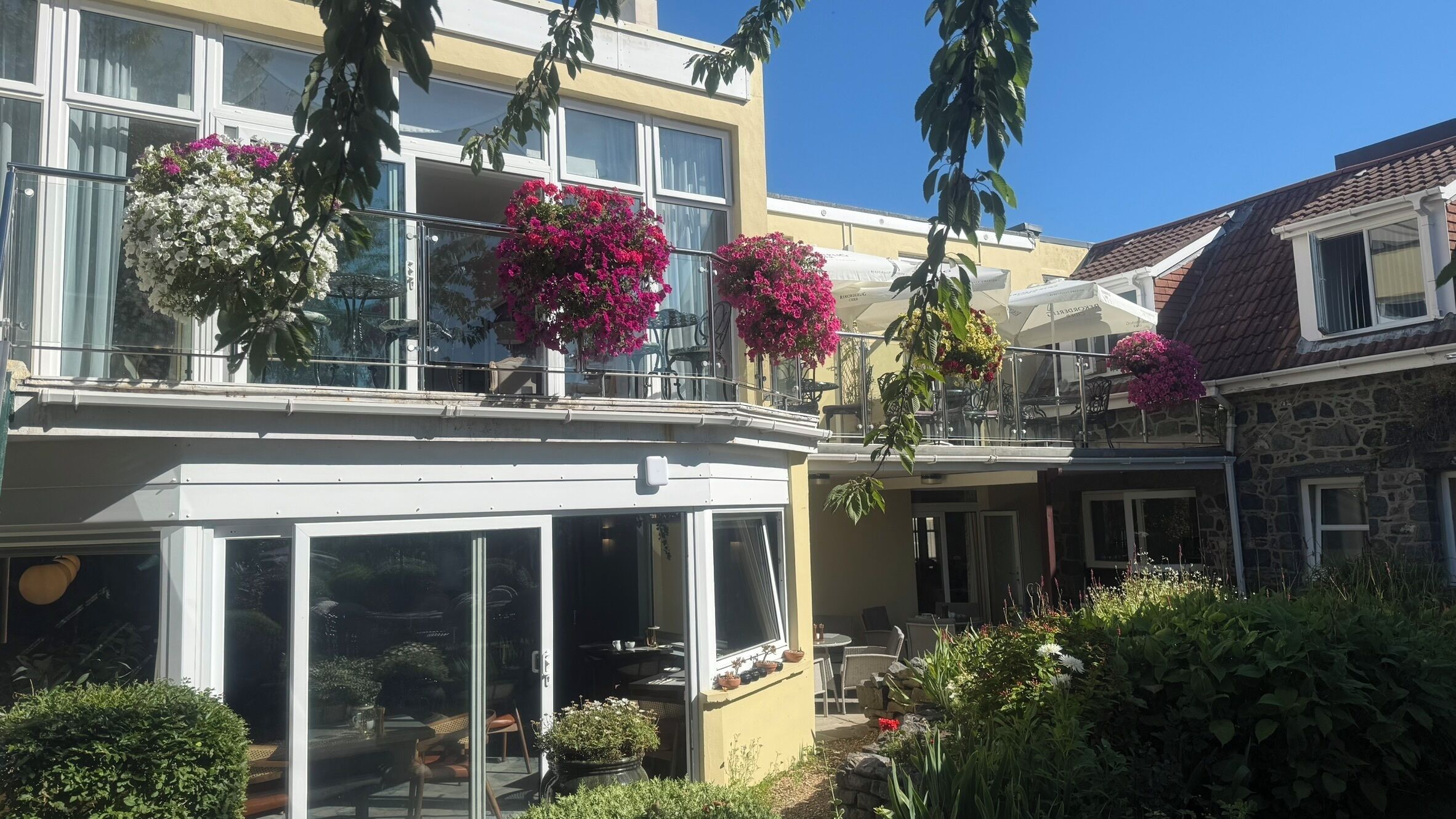 Un edificio con varios balcones, zonas de estar al aire libre y plantas en macetas.