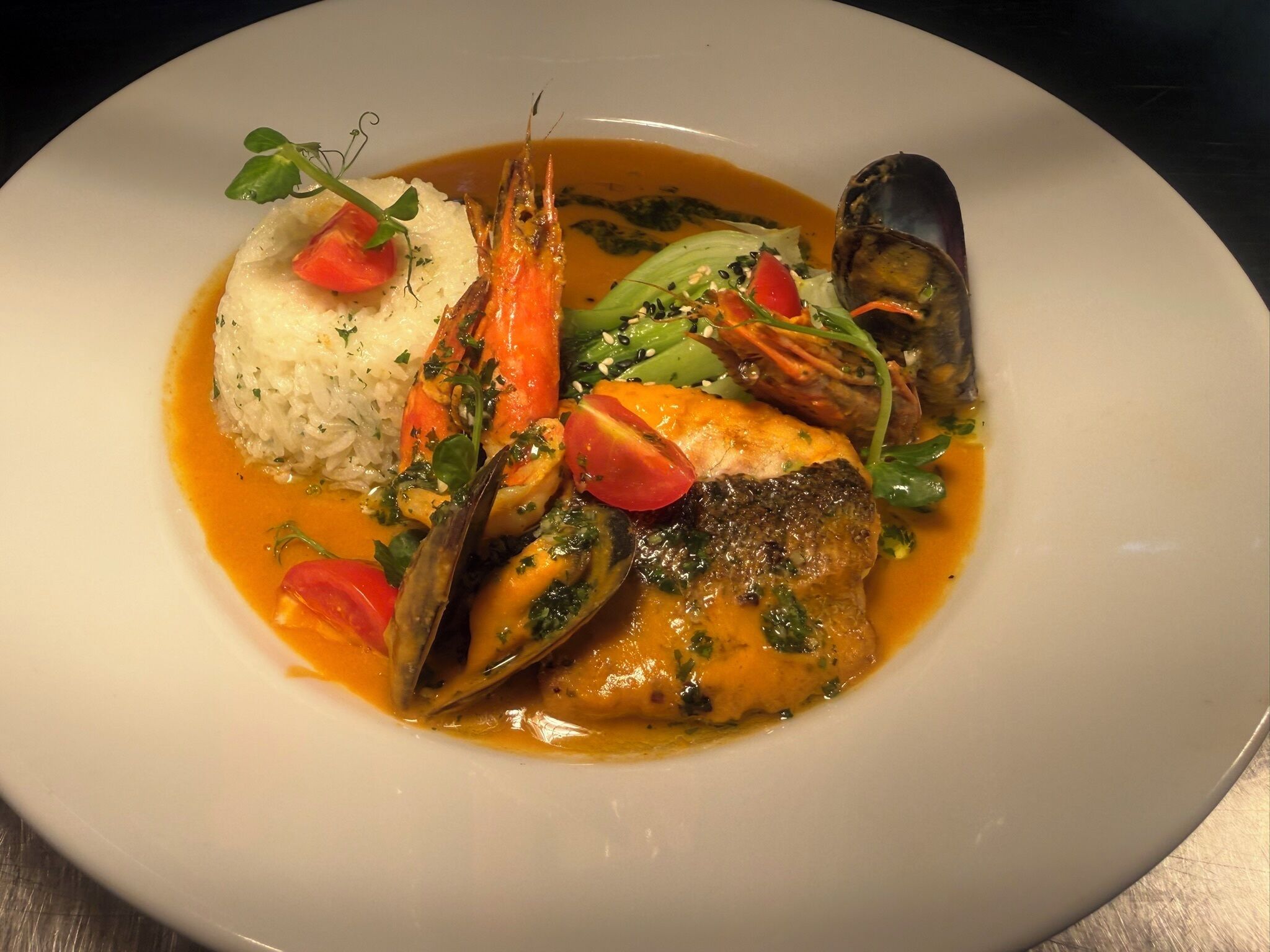 A seafood dish with rice and vegetables on a plate.