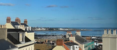 A coastal town with buildings, a marina, and the sea in the background.