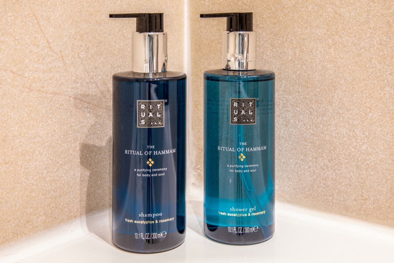 Twee flessen Ritual of Hammam shampoo en douchegel op een wit oppervlak.
