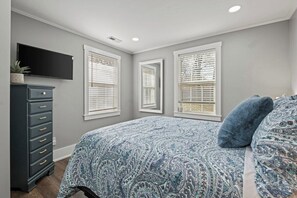 A bedroom with a bed, dresser, and three windows with blinds. - Mission Outlook - Gorgeous Home + Pet Friendly (Mission)