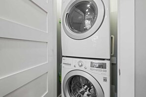 A stacked washer and dryer unit in a laundry room. - Mission Outlook - Gorgeous Home + Pet Friendly (Mission)