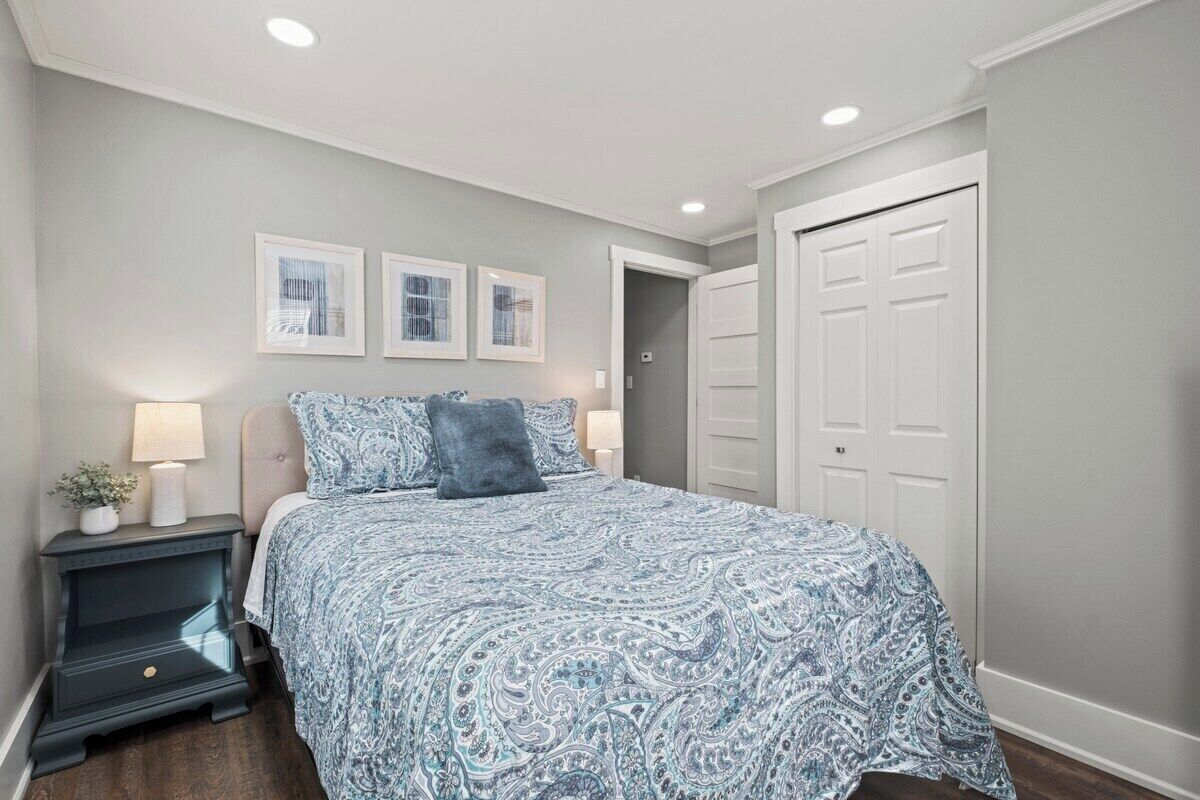 Un dormitorio con cama, mesita de noche y una puerta.