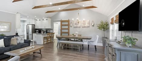 Stylish living room with seamless flow into the dining area, offering plenty of space to unwind during your stay in the quiet neighborhood of Mission, Kansas.
