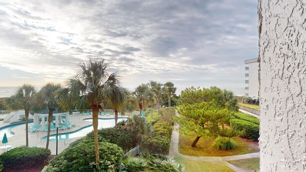 A resort with a swimming pool, palm trees, and a view of the ocean. - Seaside Bliss Oceanfront1 Bdrm Ste at Bridgewater (Pawleys Island)