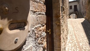 A narrow cobblestone street with a stone building entrance. - Scappo in Umbria, CasaLina (Amelia)