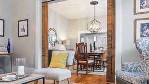 A dining area with a wooden table, chairs, and a chandelier. - The Glen Iris Getaway (Birmingham)