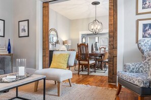 A dining area with a wooden table, chairs, and a chandelier.