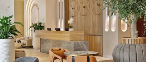 A modern reception area with a wooden reception desk, leather seating, and a potted plant.
