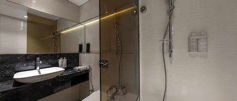 A modern bathroom with a glass-enclosed shower, a white sink, and a toilet.
