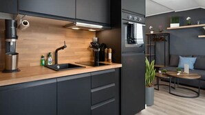 A modern kitchen with dark cabinetry, a wooden countertop, and a built-in oven.