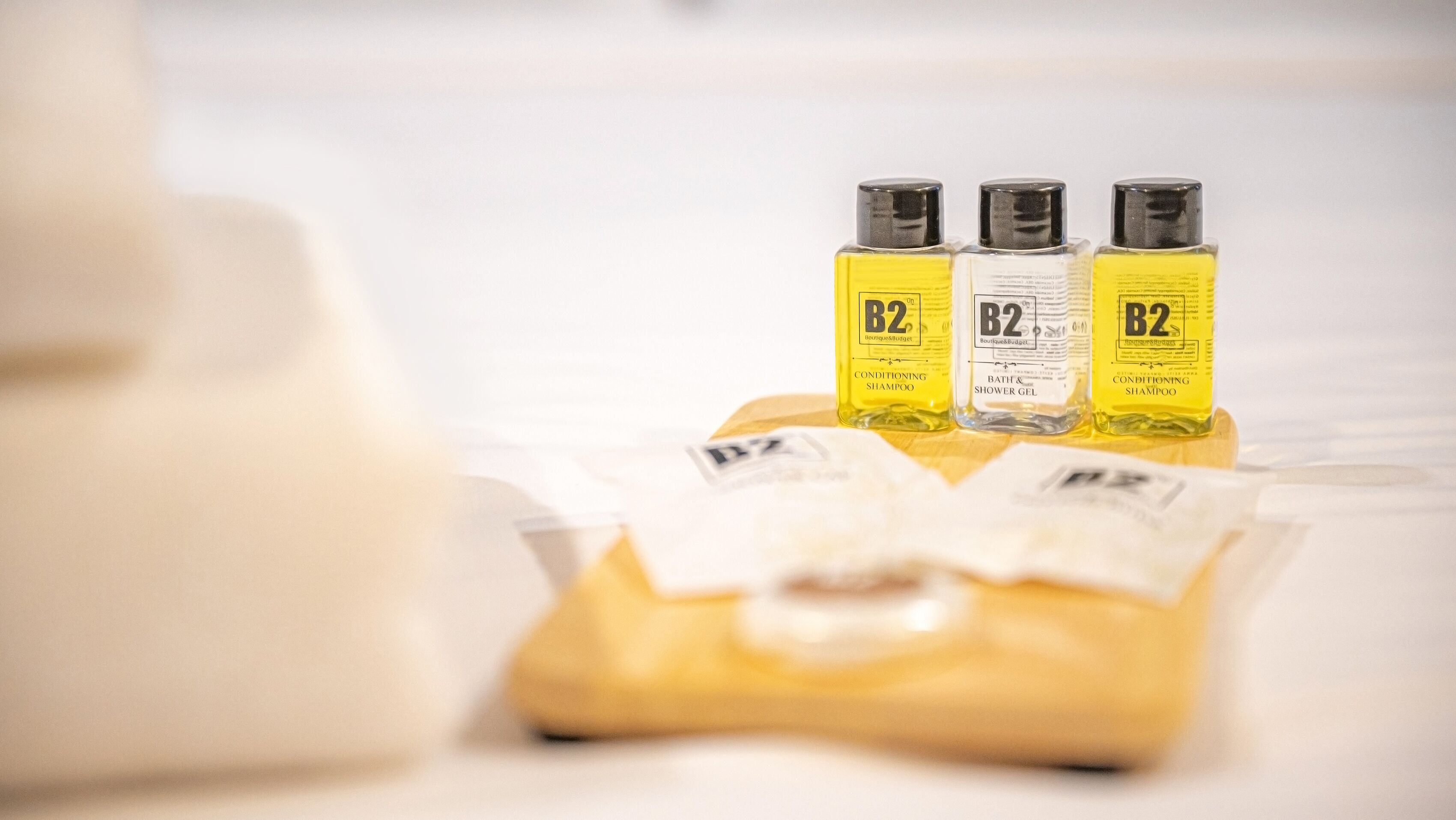 Three bottles of B2 conditioning shampoo and a bar of soap on a white surface.