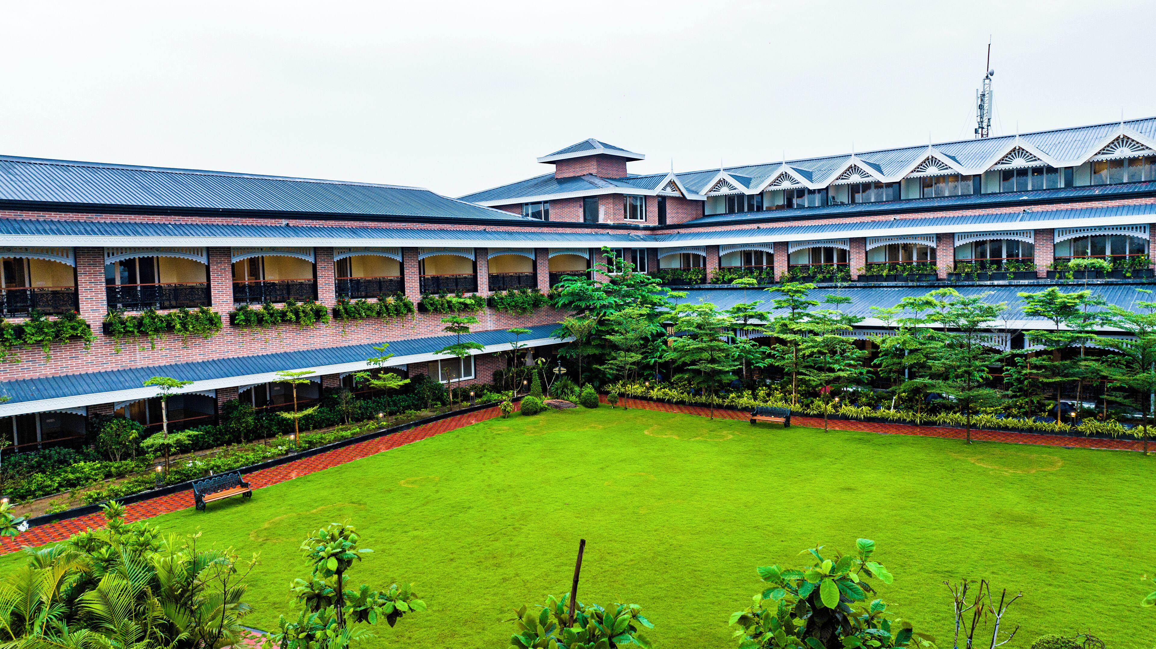 A courtyard with a central lawn, surrounded by multi-story buildings with balconies and covered walkways.
