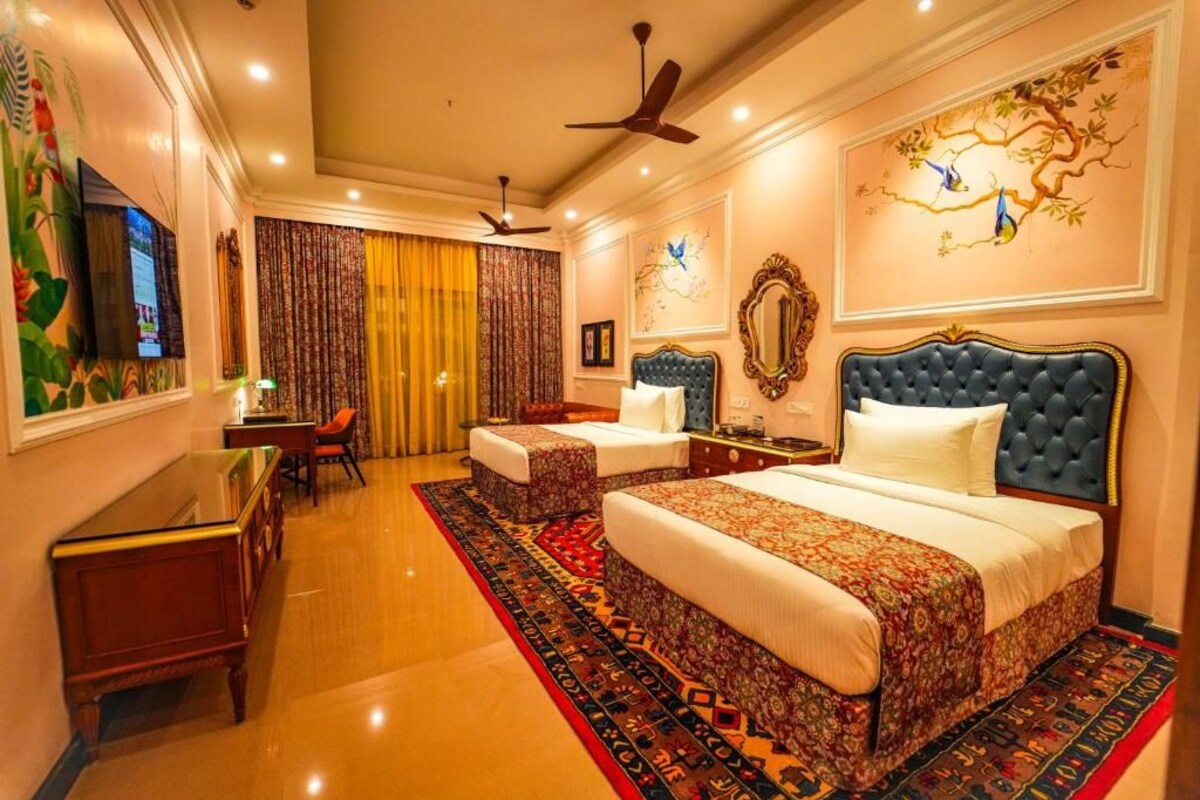 A hotel room with a large bed, two bedside tables, a desk, and a chair.