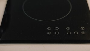 Une plaque de cuisson à induction noire dotée de boutons de commande.