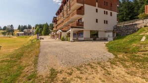 En byggnad med flera våningar, balkonger, en grusuppfart och en gräsyta.