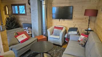 A cozy living room with a fireplace, a television, and comfortable seating.