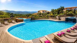 A swimming pool with lounge chairs and a view of mountains. - Mini Villa sur Santa Giulia (Porto-Vecchio)