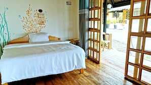 Una habitación con estructura de madera, una cama y un cartel de 'No Fumar', con vistas al exterior.