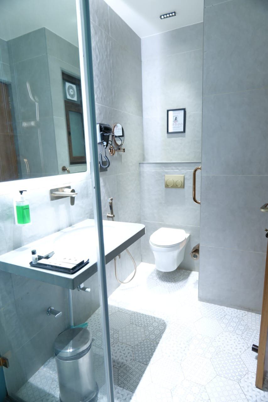 Une salle de bain moderne avec une douche à parois de verre, un lavabo blanc et des toilettes.
