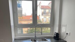 A small kitchen with a window, a sink, and cabinets.