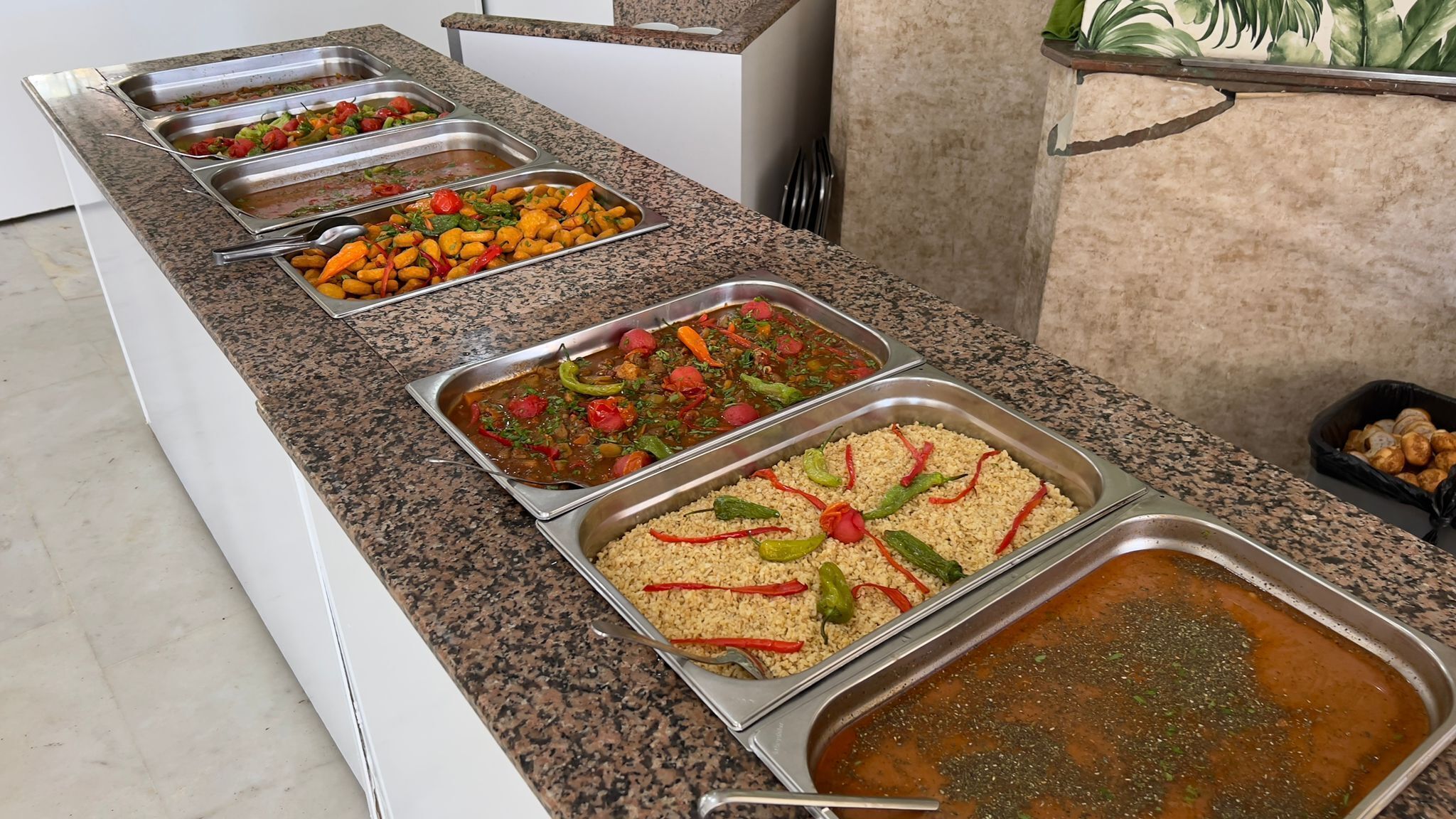 A buffet with various dishes including rice, vegetables, and a soup.