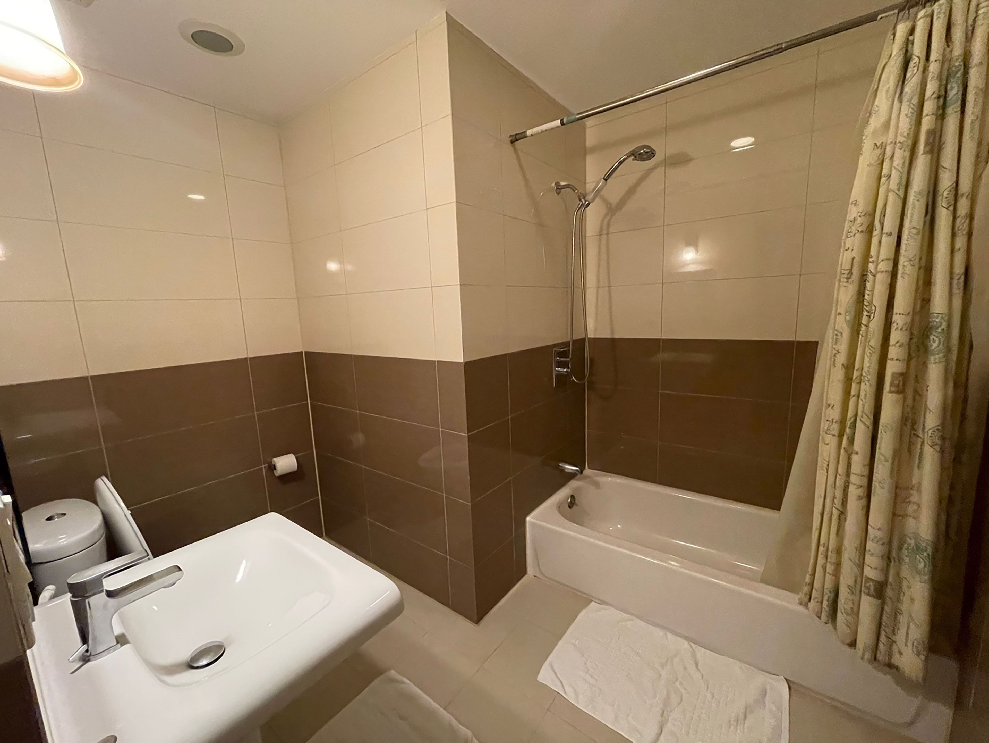 Un baño con lavamanos blanco, bañera y ducha.
