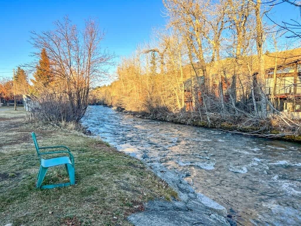 Une rivière avec un banc sur la rive gauche.