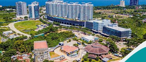 Un complesso residenziale di grattacieli con diversi edifici, un cortile centrale e vista sull'oceano.