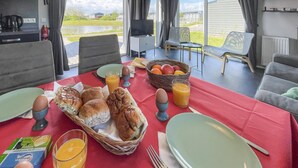 Desayuno preparado para dos personas, con pan, huevos y zumo de naranja.
