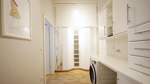 A laundry room with a washing machine, a drying rack, and a shelving unit. - HeyMi Apartments Karlsplatz (Vienna)