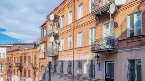 Un immeuble à plusieurs étages doté de balcons, avec un numéro de porte bien visible et une rue devant.
